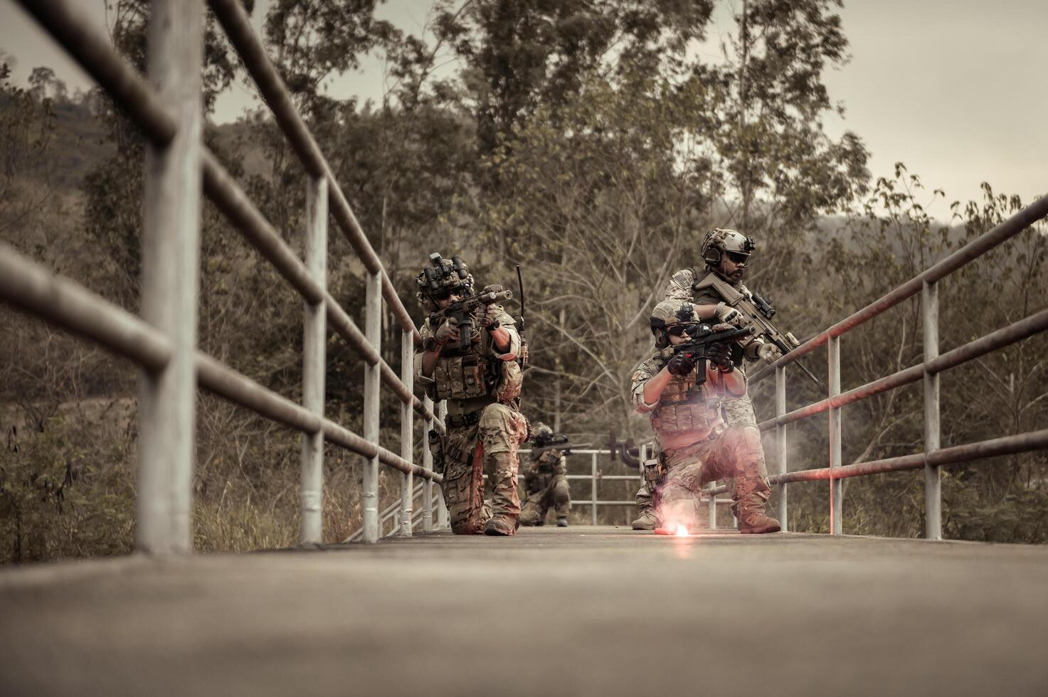 Soldiers in camouflage uniforms aiming with their riflesready to fire during Military Operation in the forest soldiers training in a military operation photo