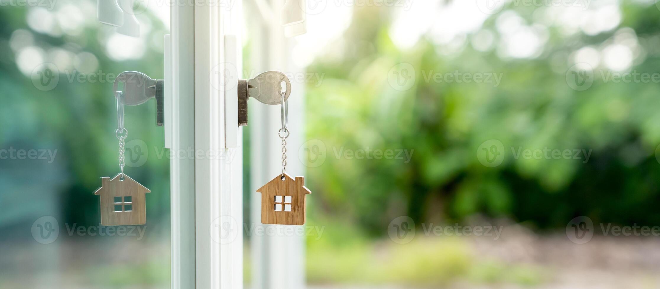 Landlord key for unlocking house is plugged into the door. Second hand house for rent and sale. keychain is blowing in the wind. mortgage for new home, buy, sell, renovate, investment, owner, estate photo