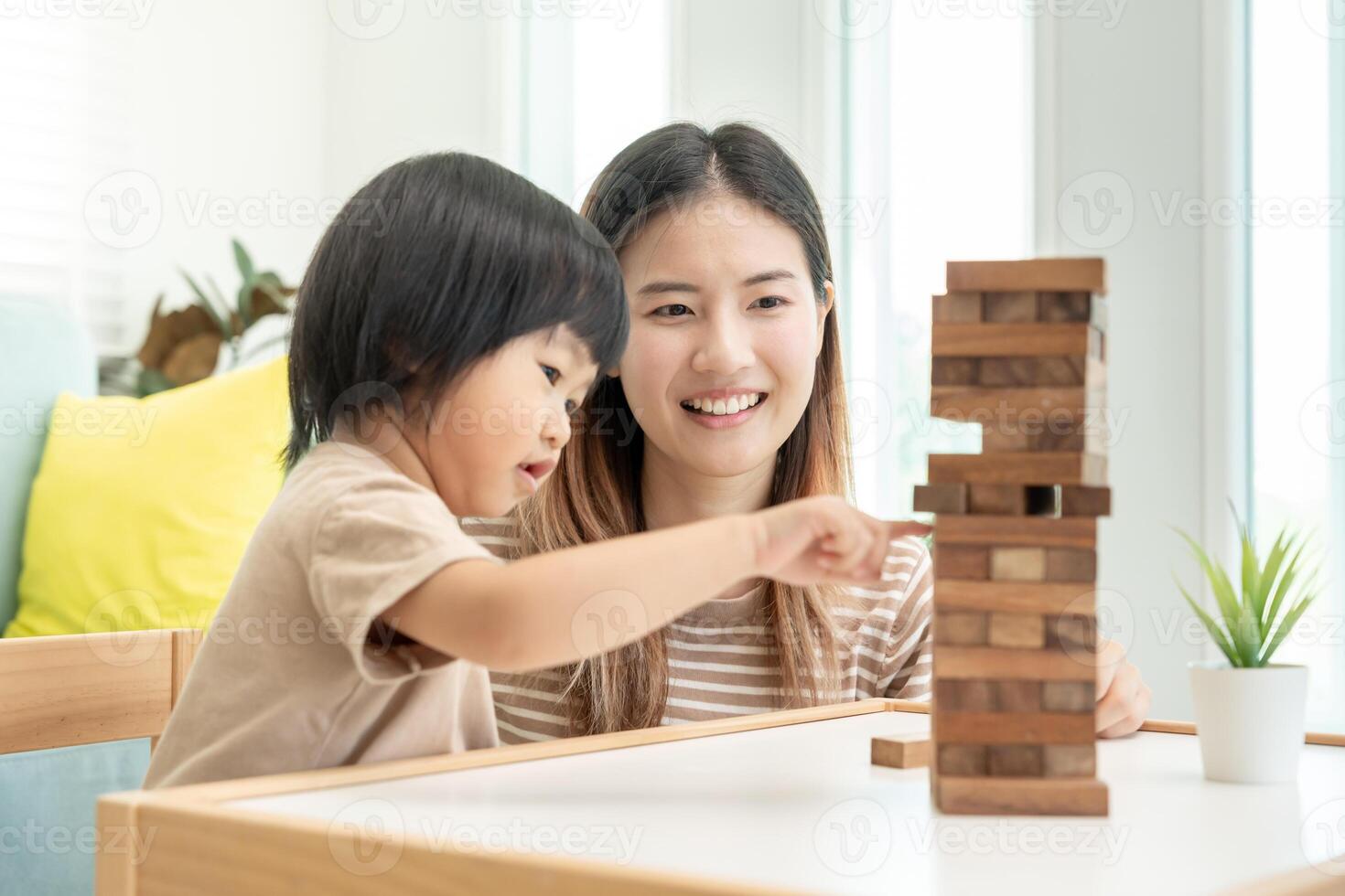 Asia Happy single mother playing learning games janga with the little boy. Funny family is happy and excited in the house. Father and son having fun spending time together. holiday, weekend, vacant. photo