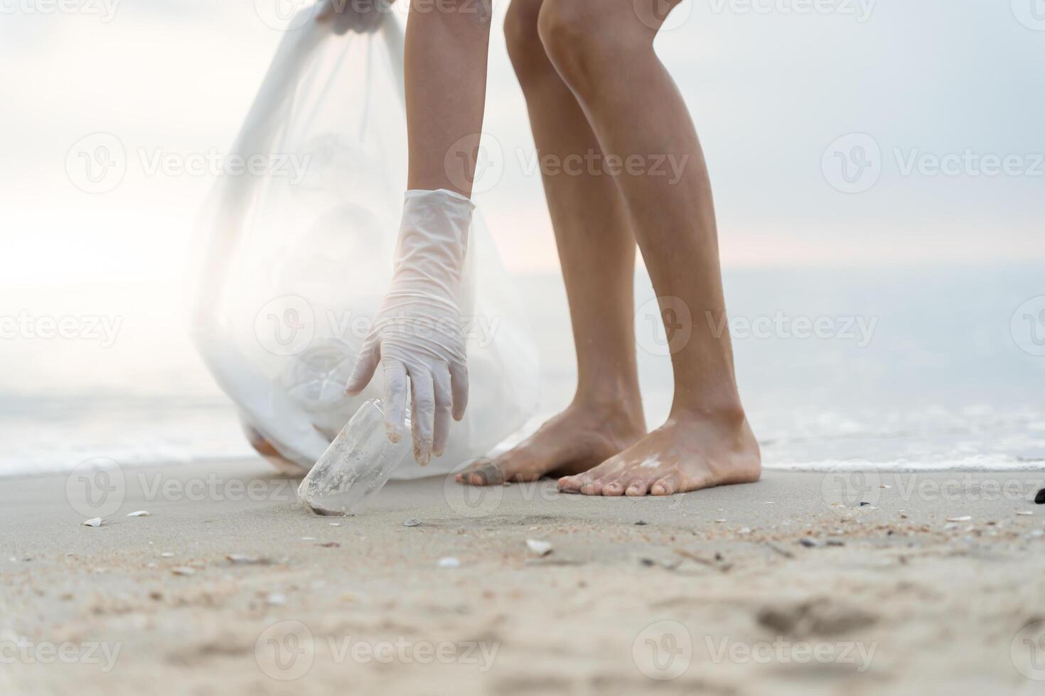 ahorrar agua. los voluntarios recogen basura en la playa y las botellas de plástico son difíciles de descomponer para evitar dañar la vida acuática. tierra, ambiente, planeta verde, reducir el calentamiento global, salvar el mundo foto