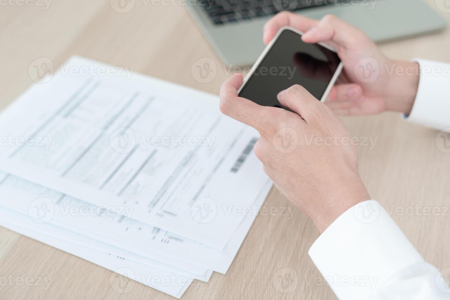 business man use phone to scan barcode or QR codes to pay credit card bill after receiving document invoice online. payment, receive, paying electricity, digital payments without money, technology photo