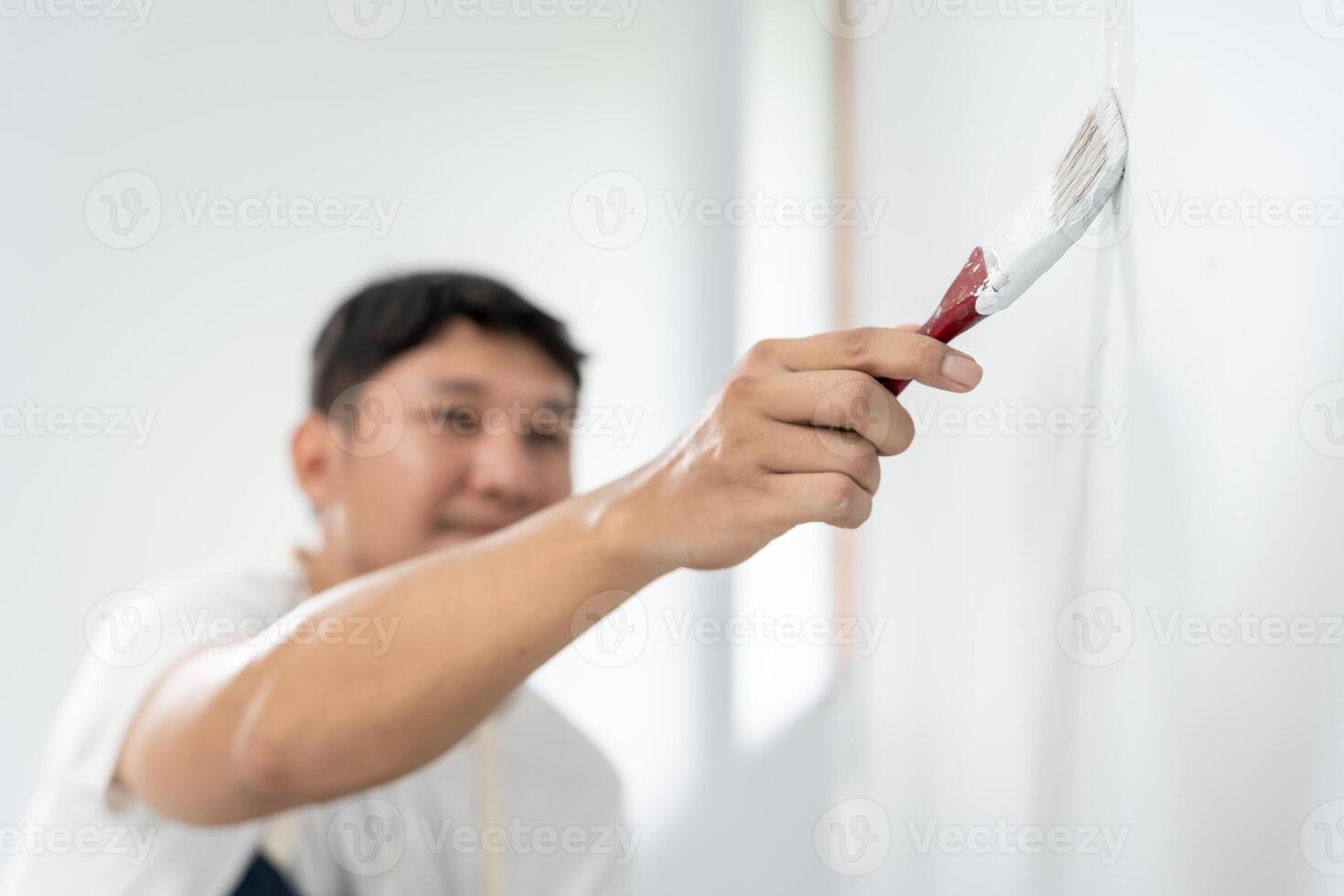 painter man, brush in hand for products to restore and paint the wall, indoor the building site of a house, wall during painting, renovation, painting, contractor, Architect, construction worker photo