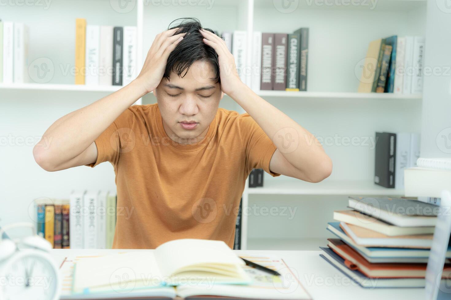 el estudiante asiático tiene ansiedad debido a los exámenes, los hombres se preparan para el examen y aprenden lecciones en la biblioteca. estrés, desesperación, prisa, malentendido lectura, desanimado, expectativa, conocimiento, cansado foto