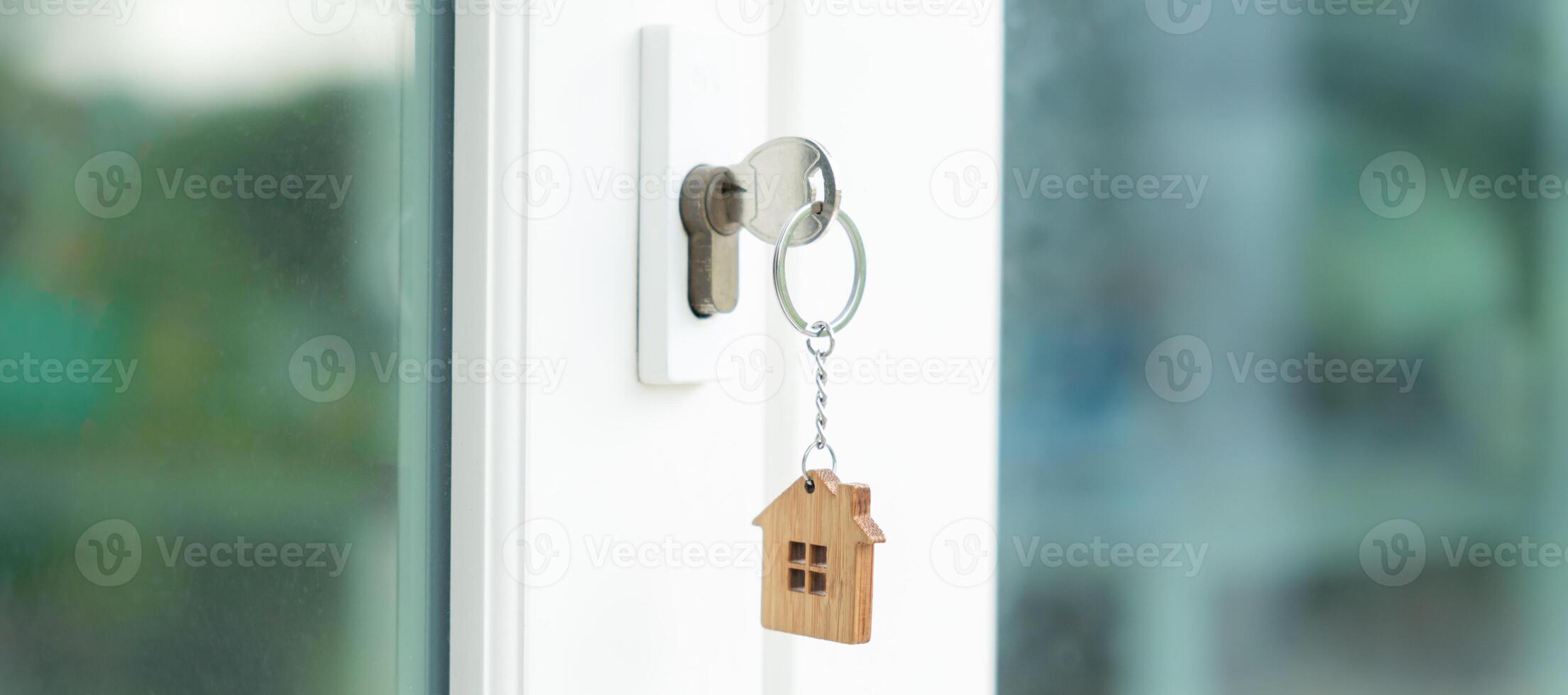 Landlord key for unlocking house is plugged into the door. Second hand house for rent and sale. keychain is blowing in the wind. mortgage for new home, buy, sell, renovate, investment, owner, estate photo