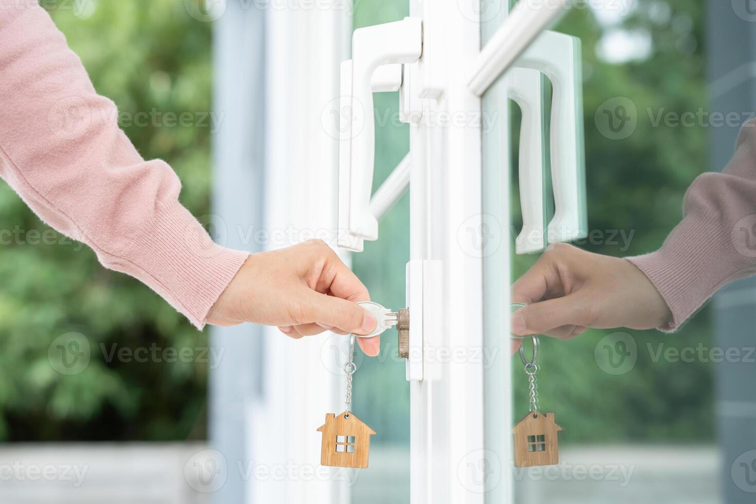 Landlord key for unlocking house is plugged into the door. Second hand house for rent and sale. Owner use hand unlock door mortgage for new home, buy, sell, renovate, investment, owner, estate photo