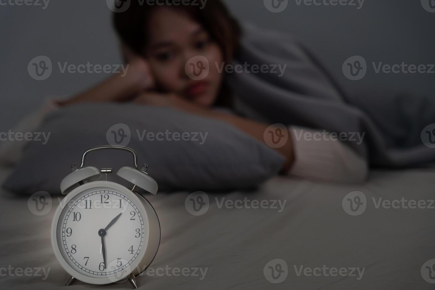 asiático mujer en cama tarde molesto a dormir sufrimiento insomnio, insomne o asustado en un pesadilla, mirando triste preocupado y estresado. cansado y dolor de cabeza o migraña despertar arriba en el medio de el noche. foto