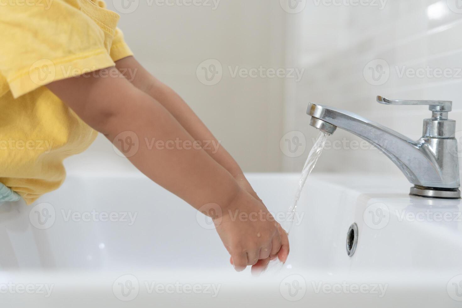 little kid hands wash with soap bubbles and rinse with clean water to prevent and stop the spread of germs after back to home, virus or covid19. Good health and good personal hygiene, virus, bacteria photo