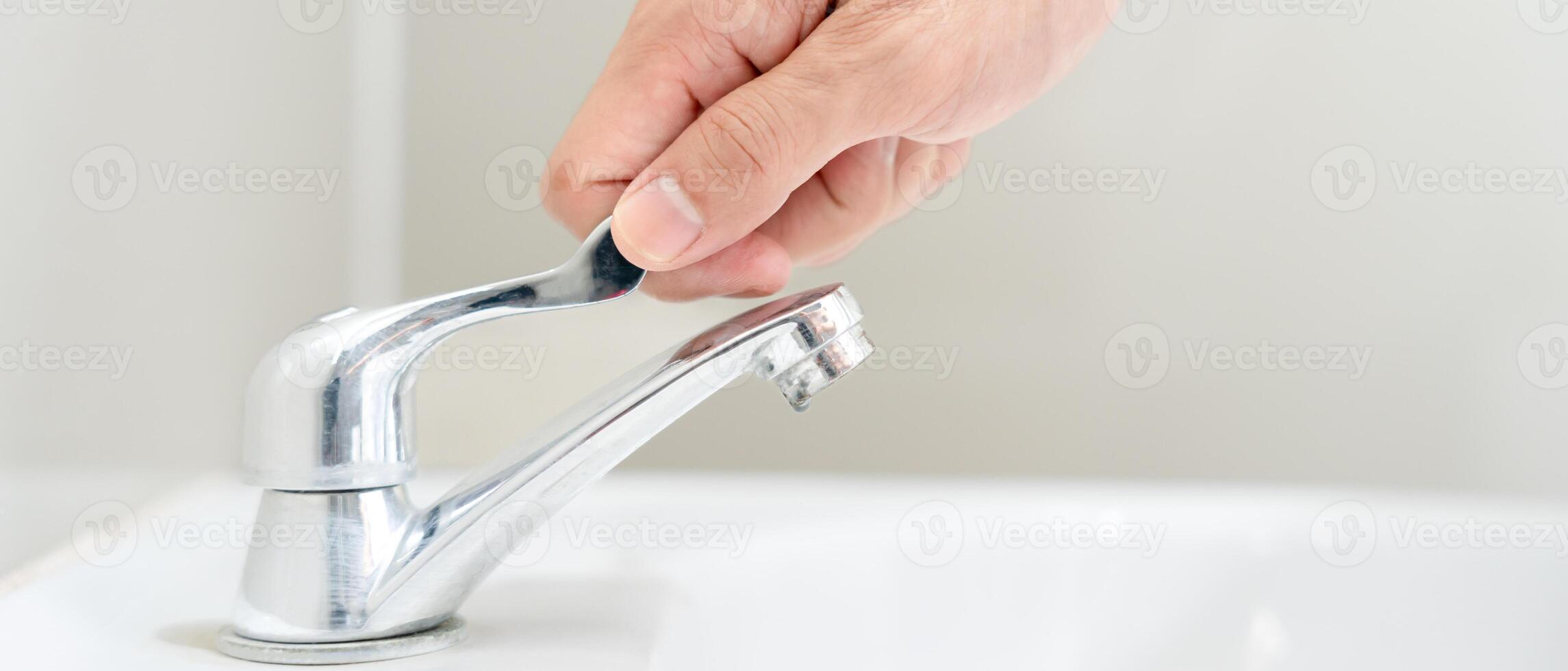 salvar agua. hombre mantiene torneado apagado el corriendo agua en el baño a proteger ambiente. verdeado planeta, reducir global calentamiento, salvar mundo, vida, futuro, riesgo energía, crisis , agua día. foto