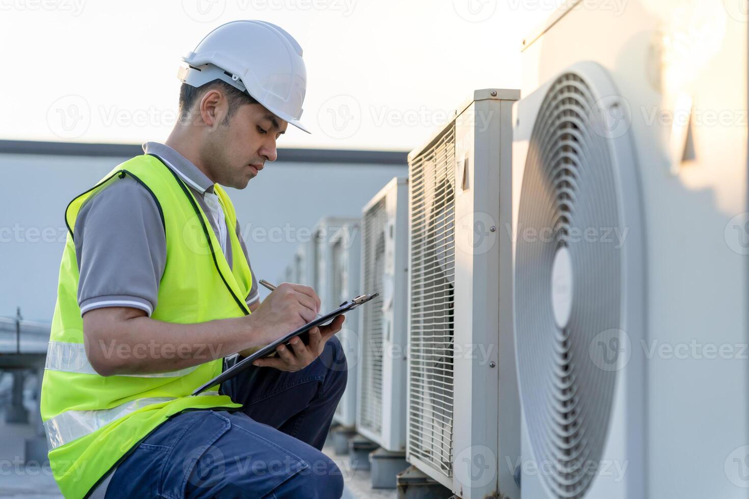 Asian maintenance engineer works on the roof of factory. contractor inspect compressor system and plans installation of air condition systems in construction. Checklist, inspector, control photo