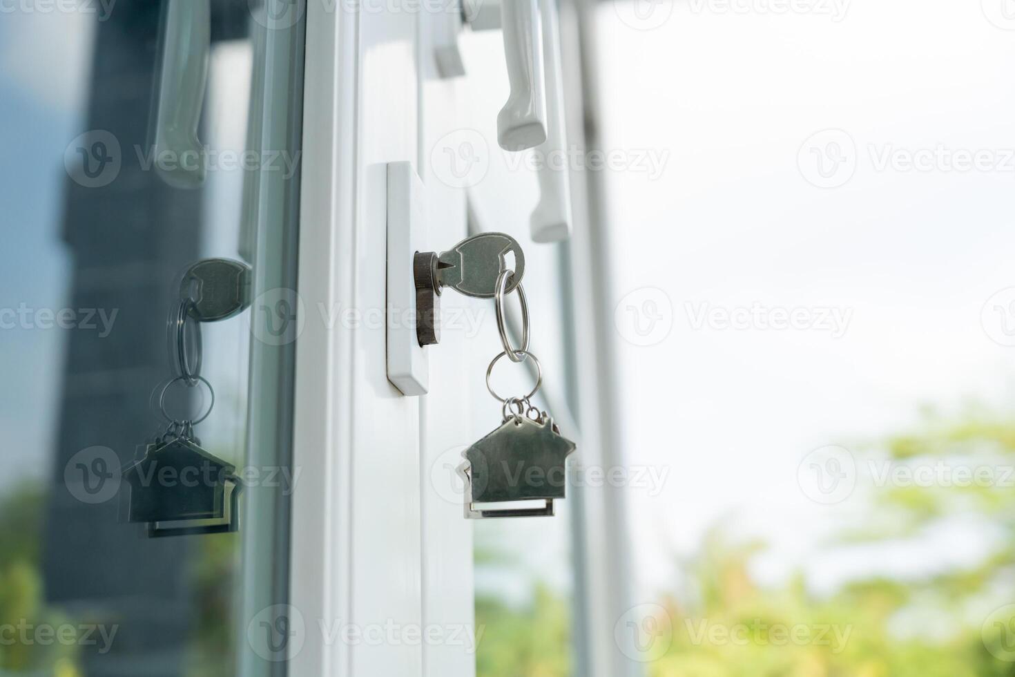 Landlord key for unlocking house is plugged into the door. Second hand house for rent and sale. keychain is blowing in the wind. mortgage for new home, buy, sell, renovate, investment, owner, estate photo
