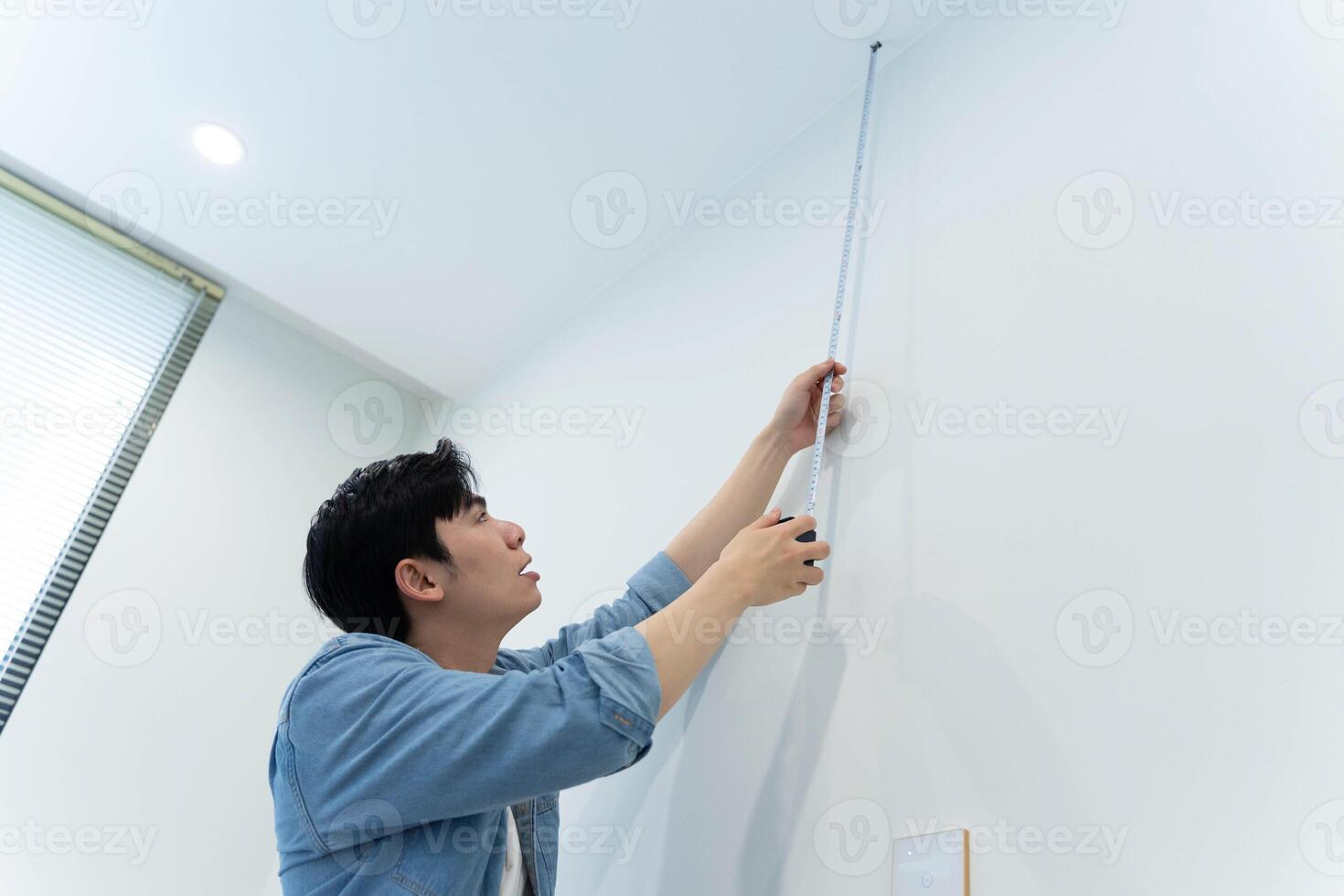 Asian man measuring and repairing houses photo