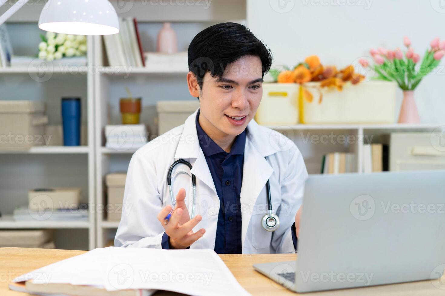 Photo of young Asian male doctor working at office