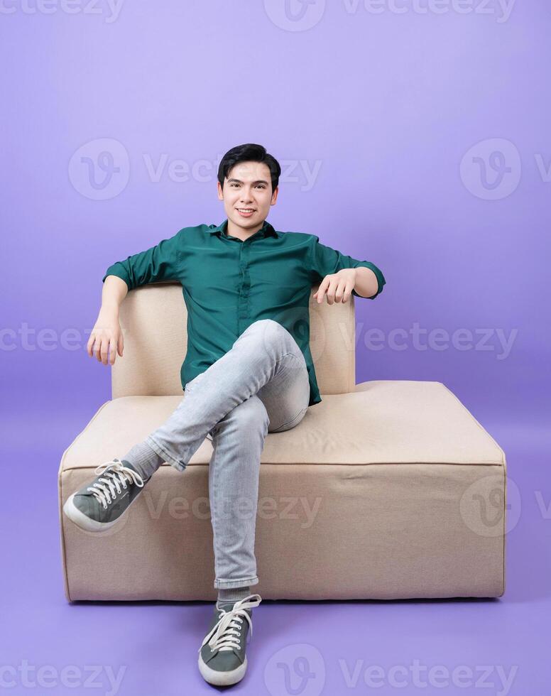 Young Asian businessman on purple background photo
