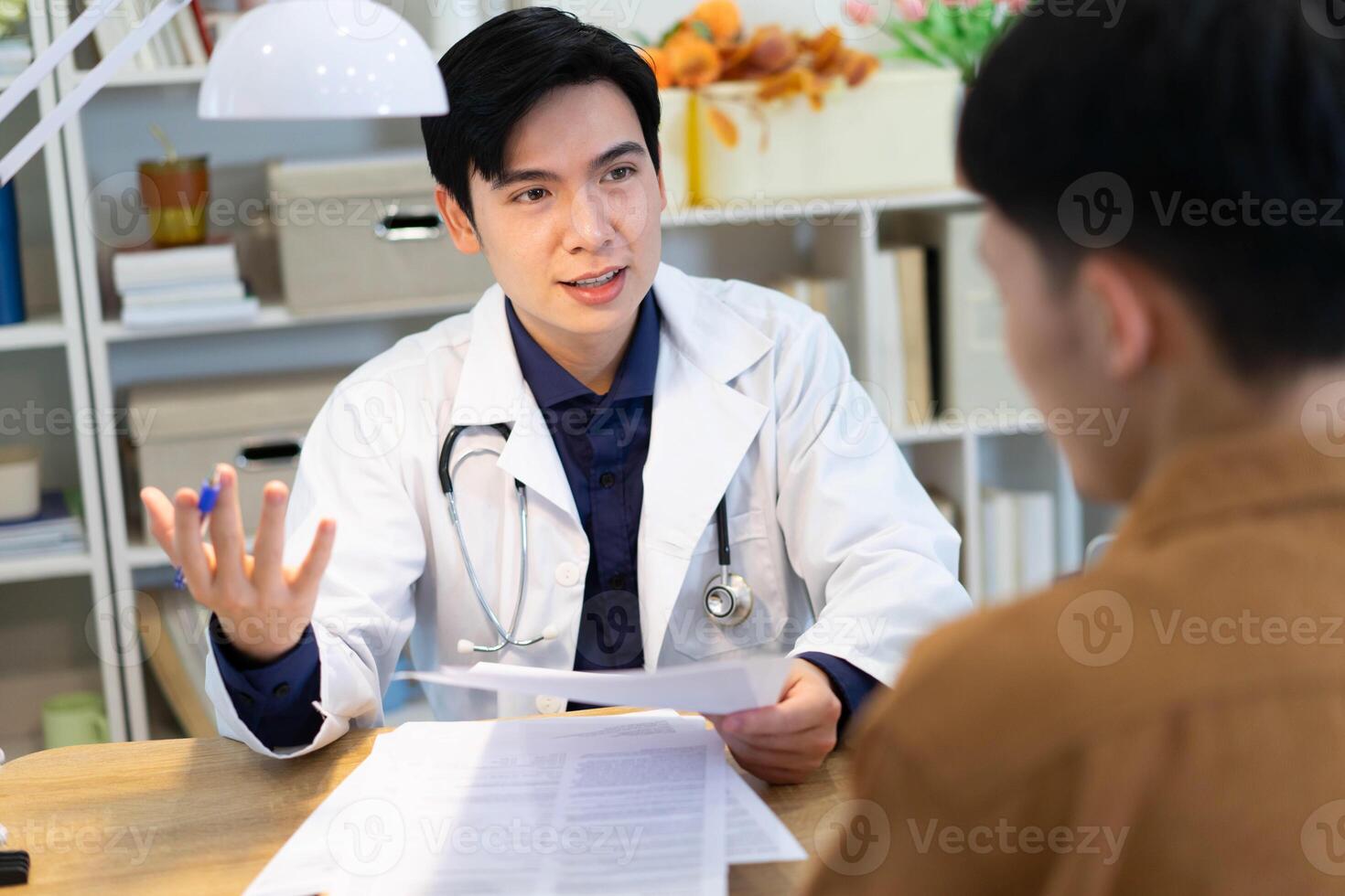 Photo of young Asian male doctor working at office