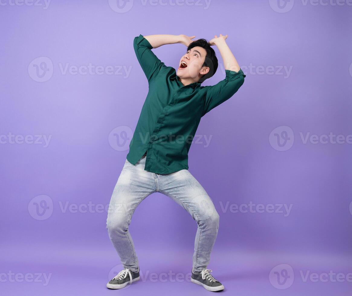 Young Asian businessman on purple background photo