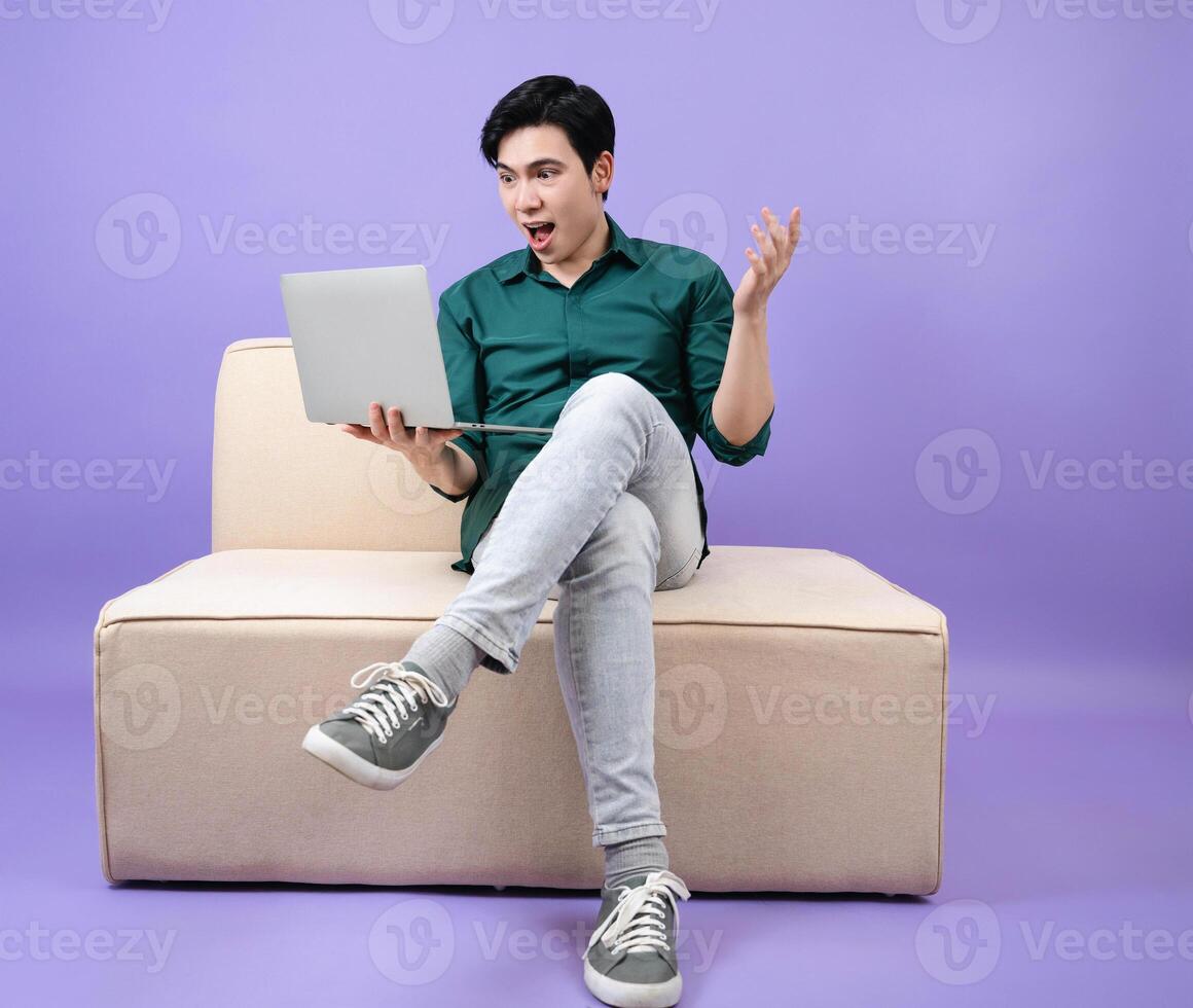 Young Asian businessman on purple background photo