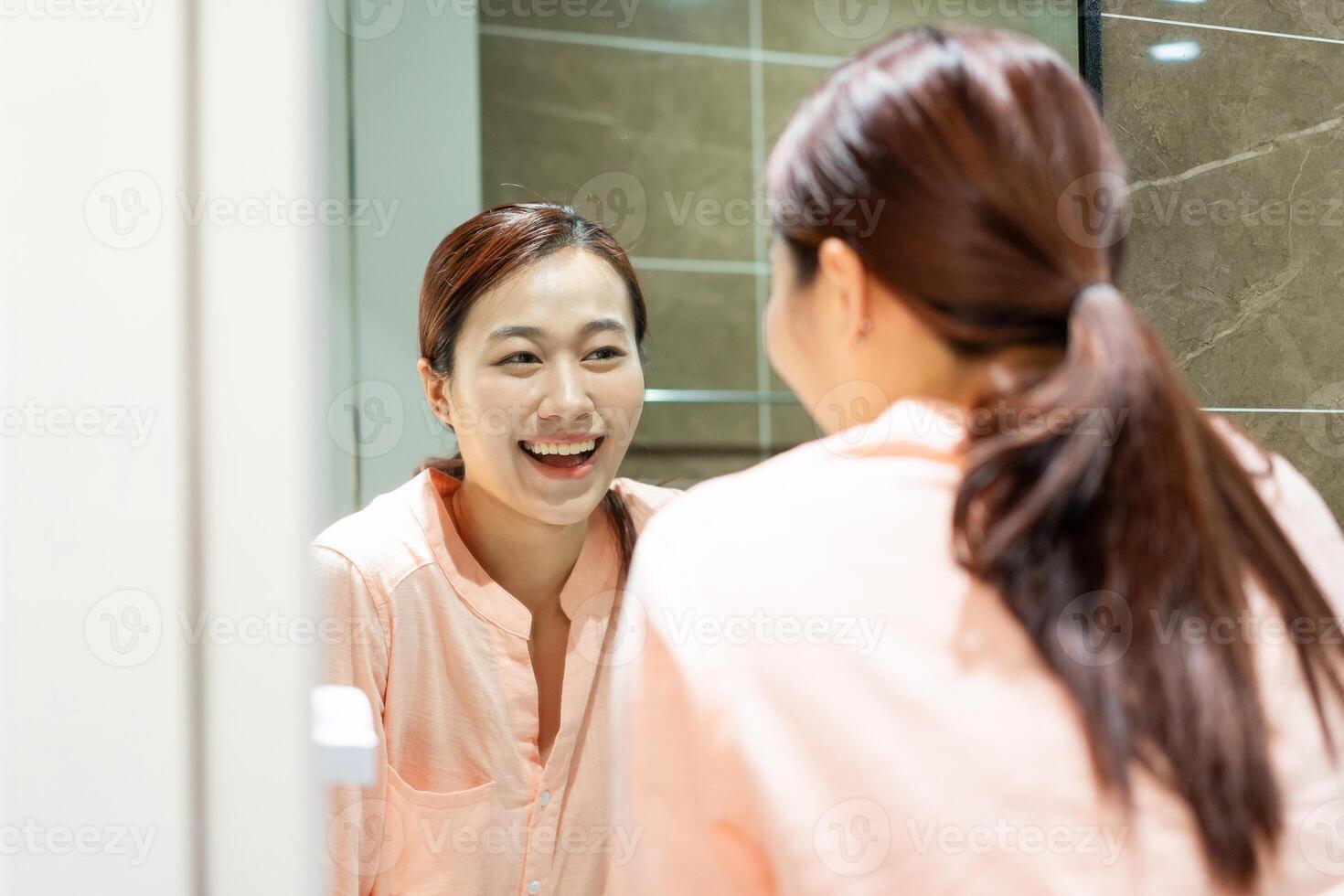 Photo of young Asian woman in bathroom