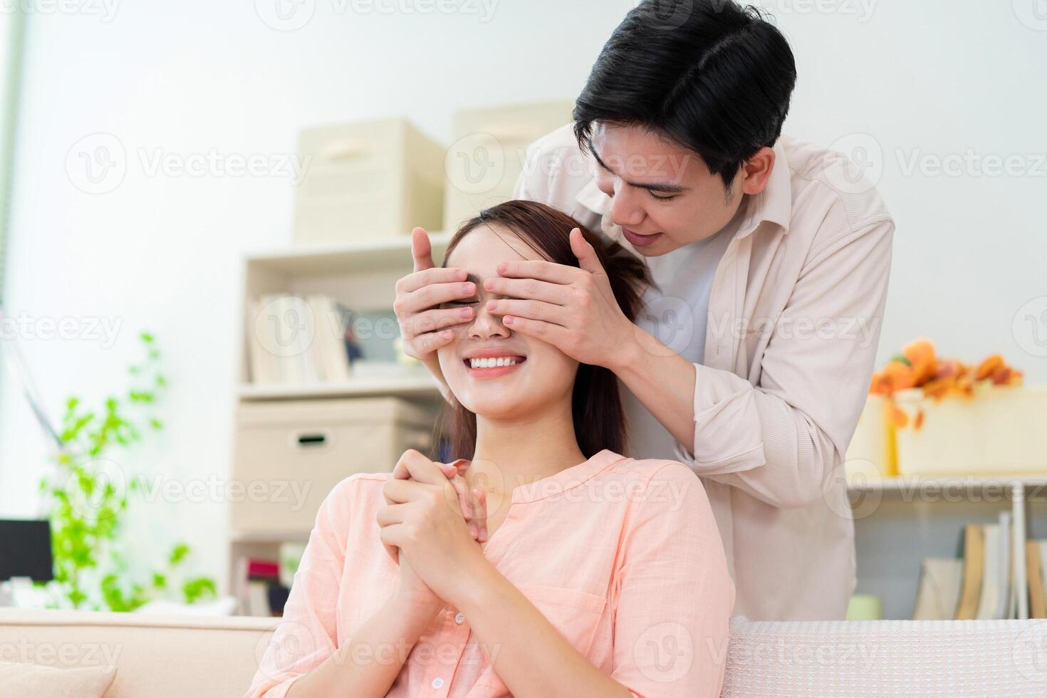 Photo of young Asian couple at home