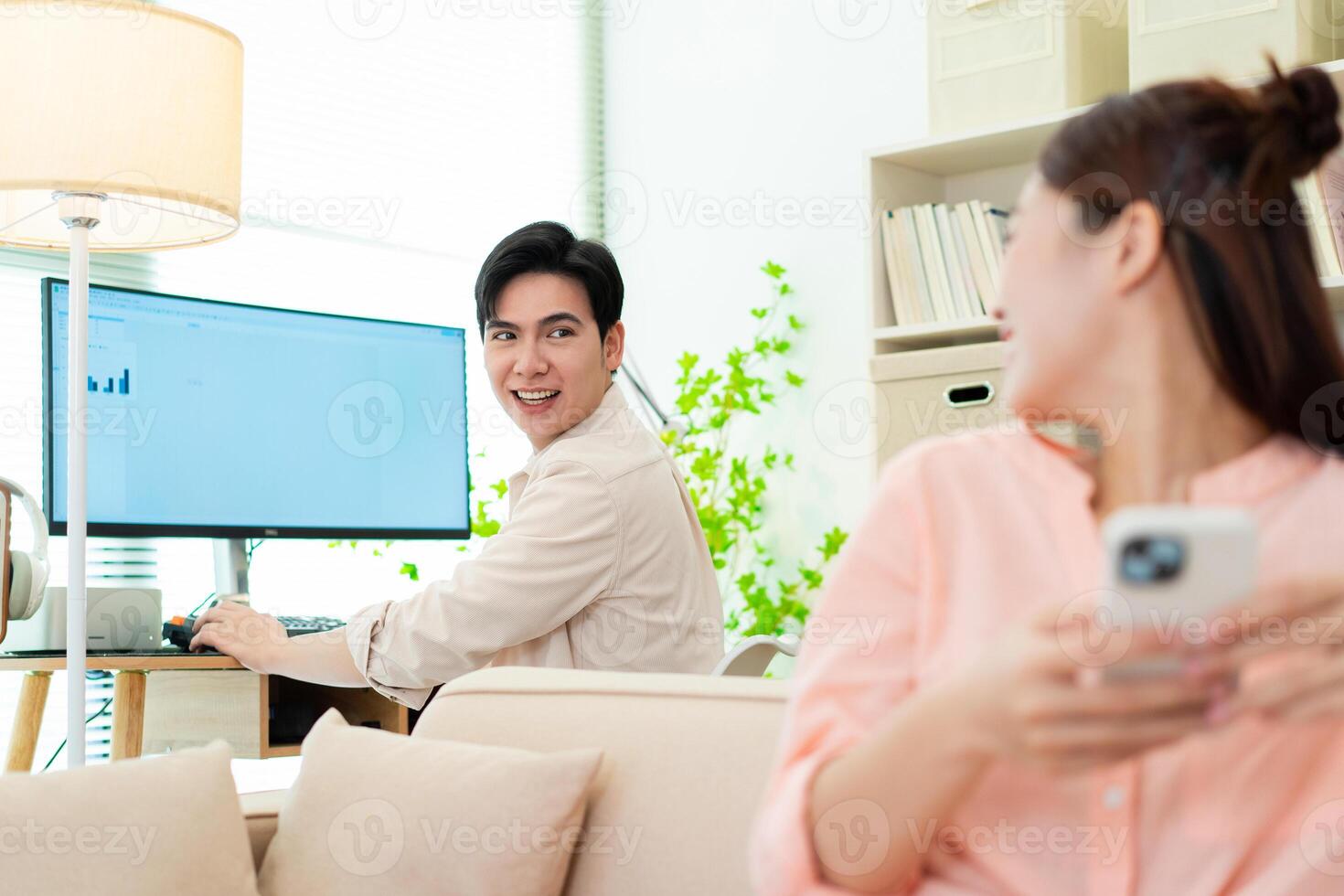 Photo of young Asian couple at home