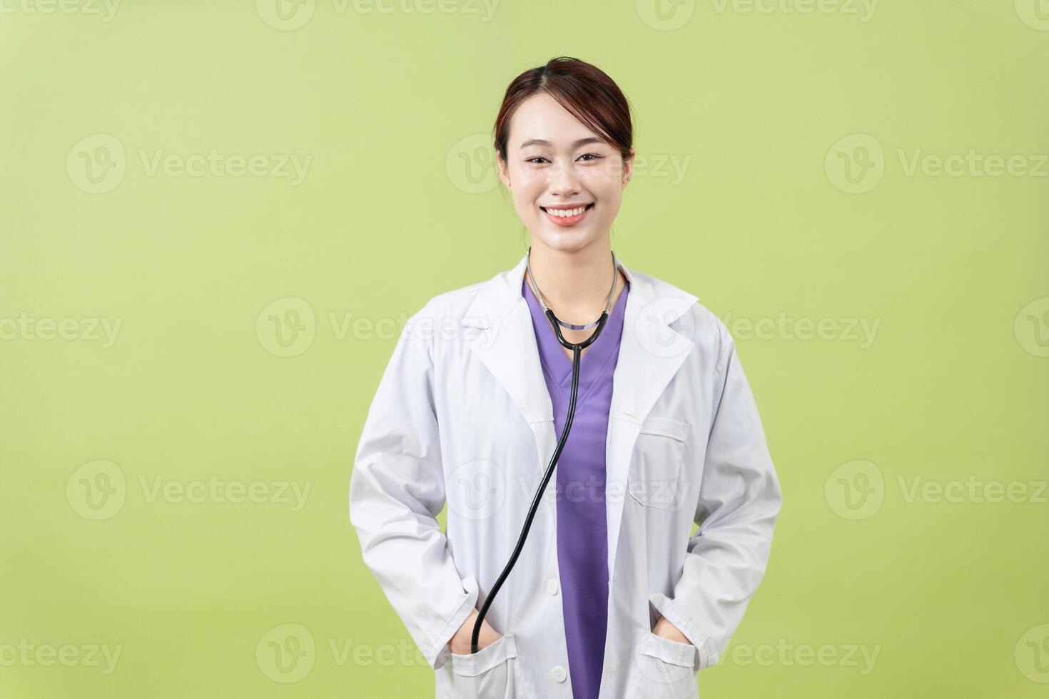 Photo of young Asian femle doctor on green background