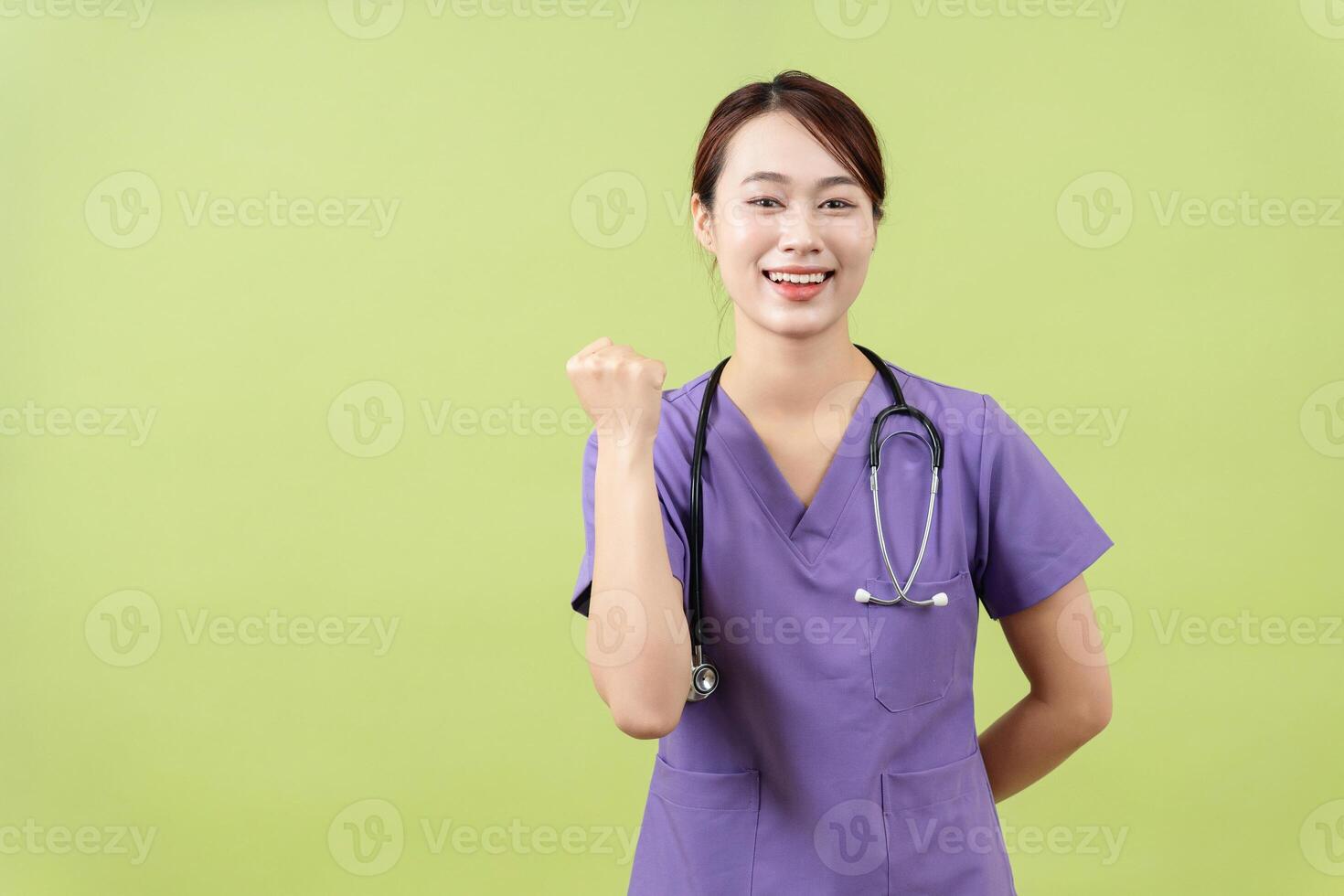 Photo of young Asian femle doctor on green background