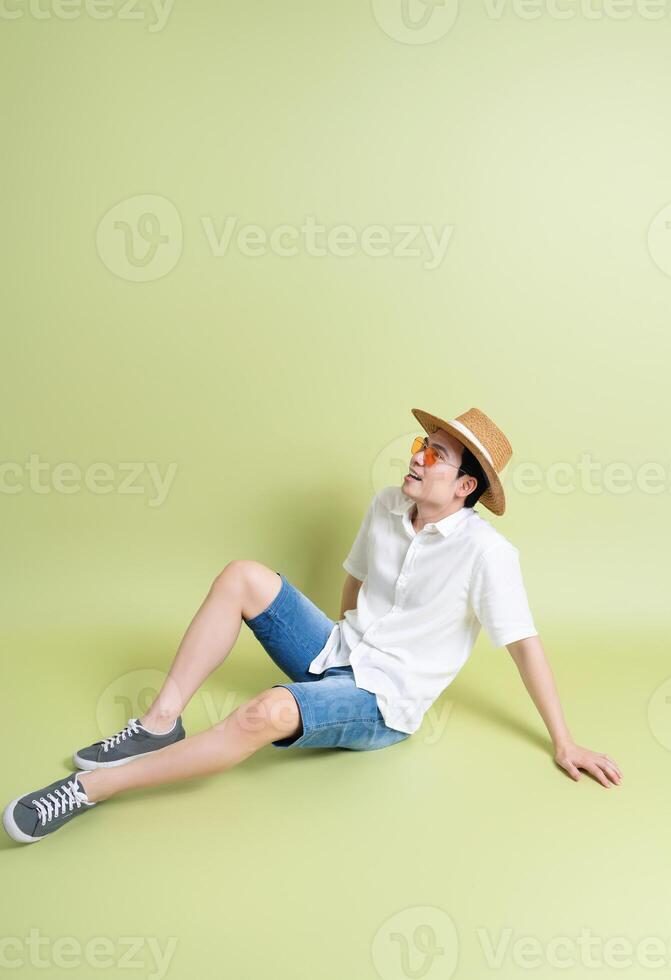 Photo of young Asian man on green background