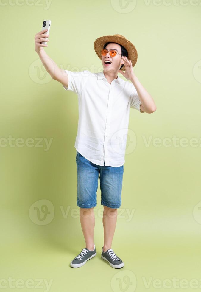 foto de joven asiático hombre en verde antecedentes