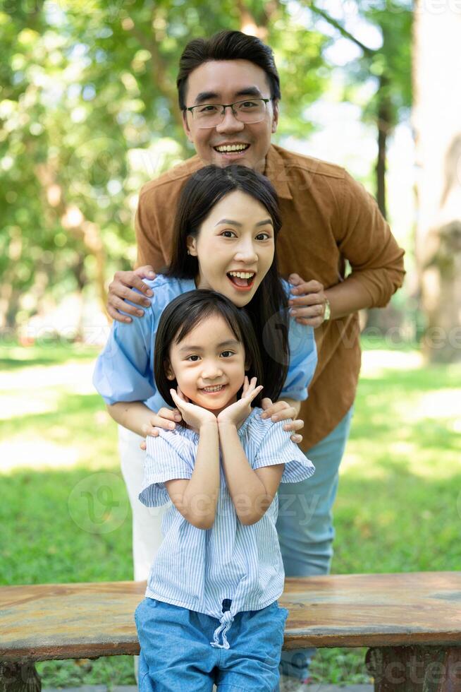 Photo of young Asian family at park