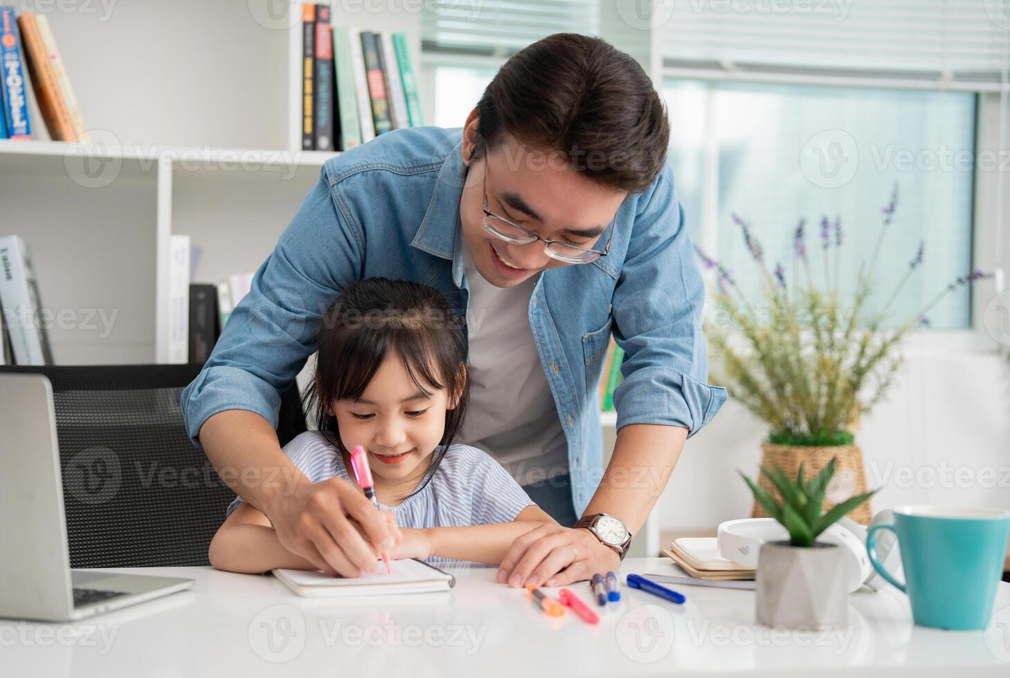 Photo of Asian father and daughter studying at home