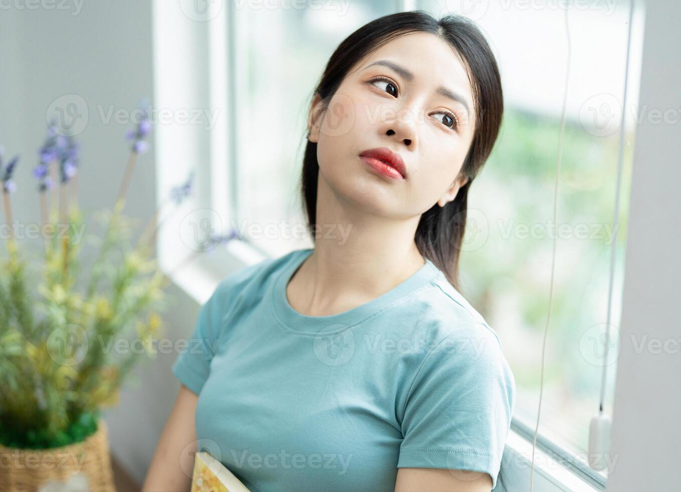 Photo of young Asian woman at home