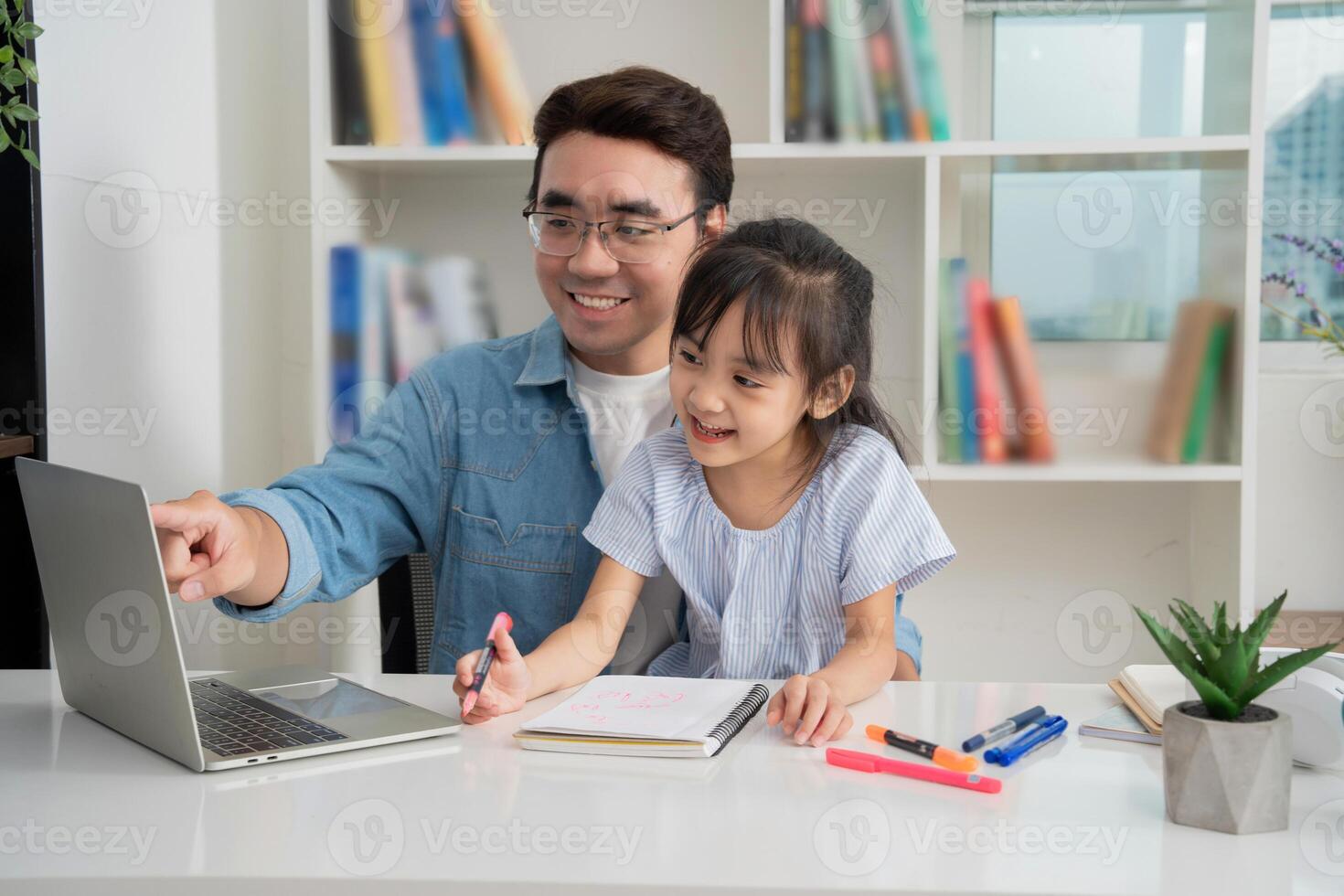 Photo of Asian father and daughter studying at home
