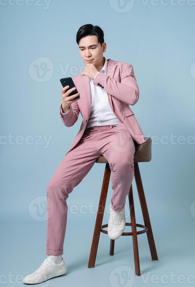 Photo of young Asian businessman wearing pink suit on background