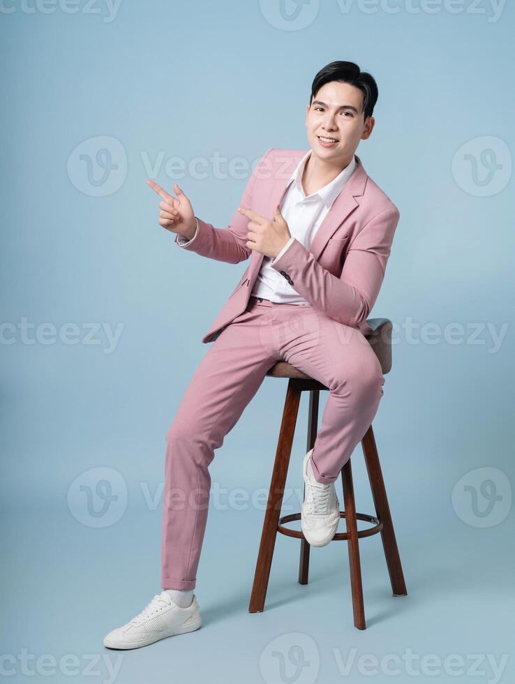 Photo of young Asian businessman wearing pink suit on background