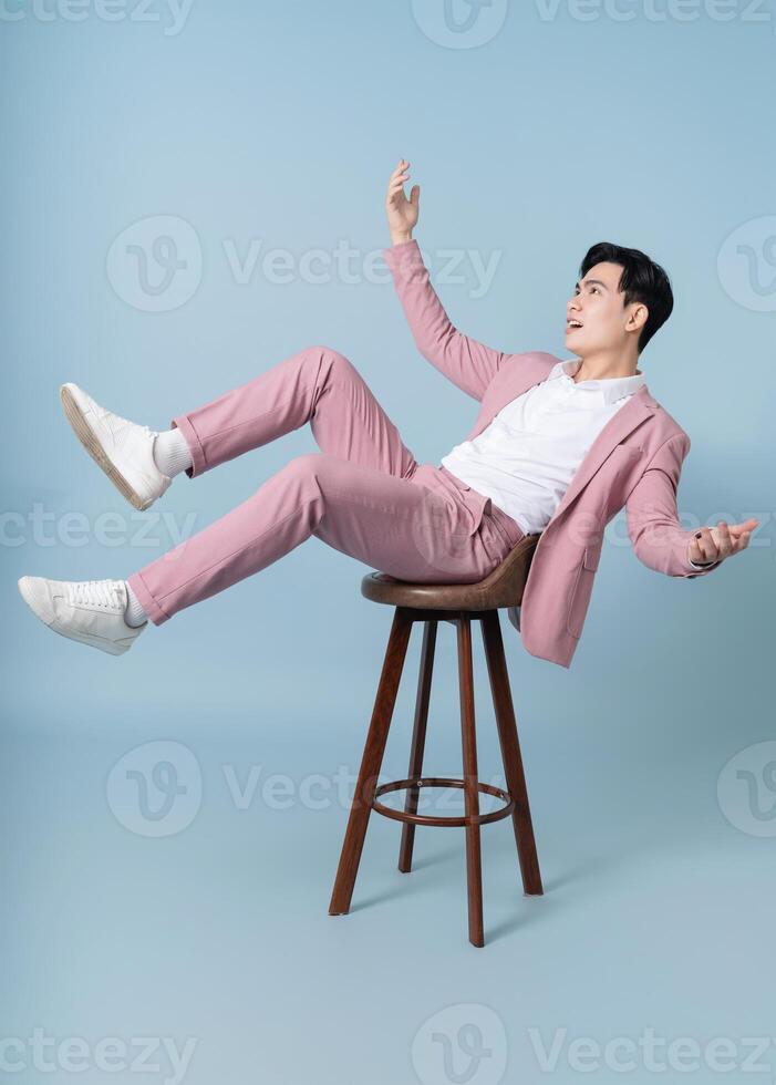 Photo of young Asian businessman wearing pink suit on background