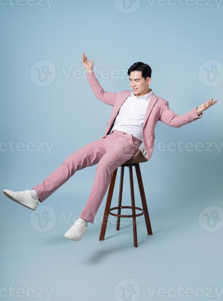 Photo of young Asian businessman wearing pink suit on background