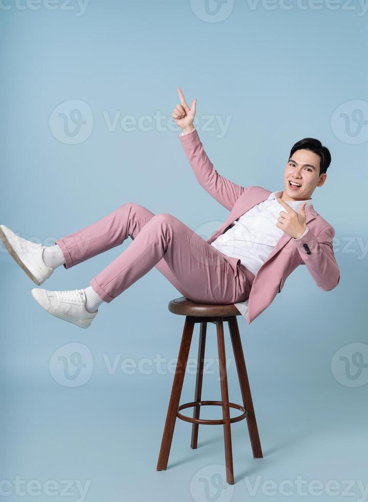 Photo of young Asian businessman wearing pink suit on background