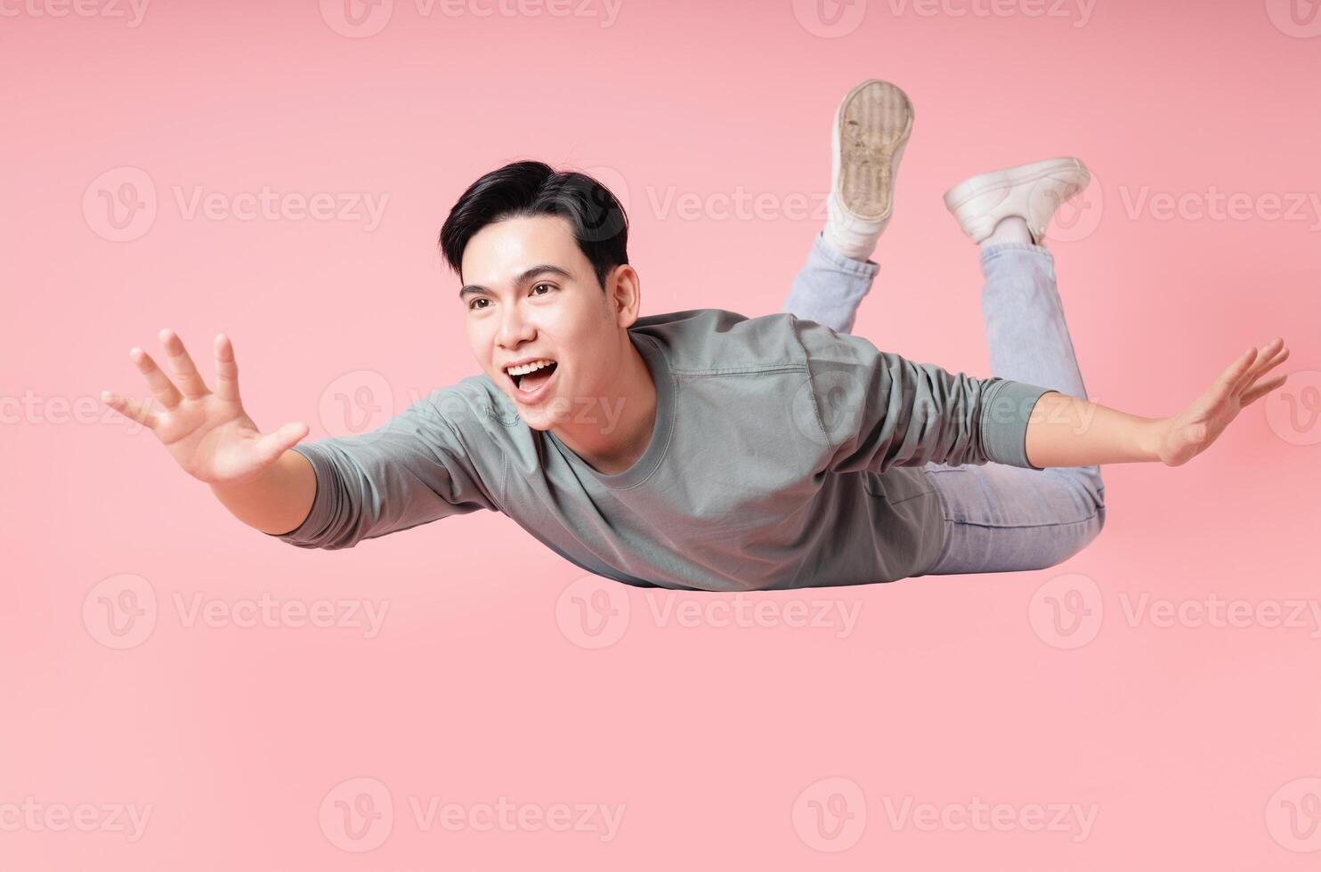 Photo of young Asian man flying on background