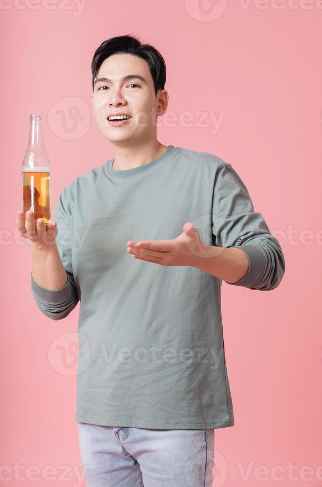 Photo of young Asian man drinking alcohol on background