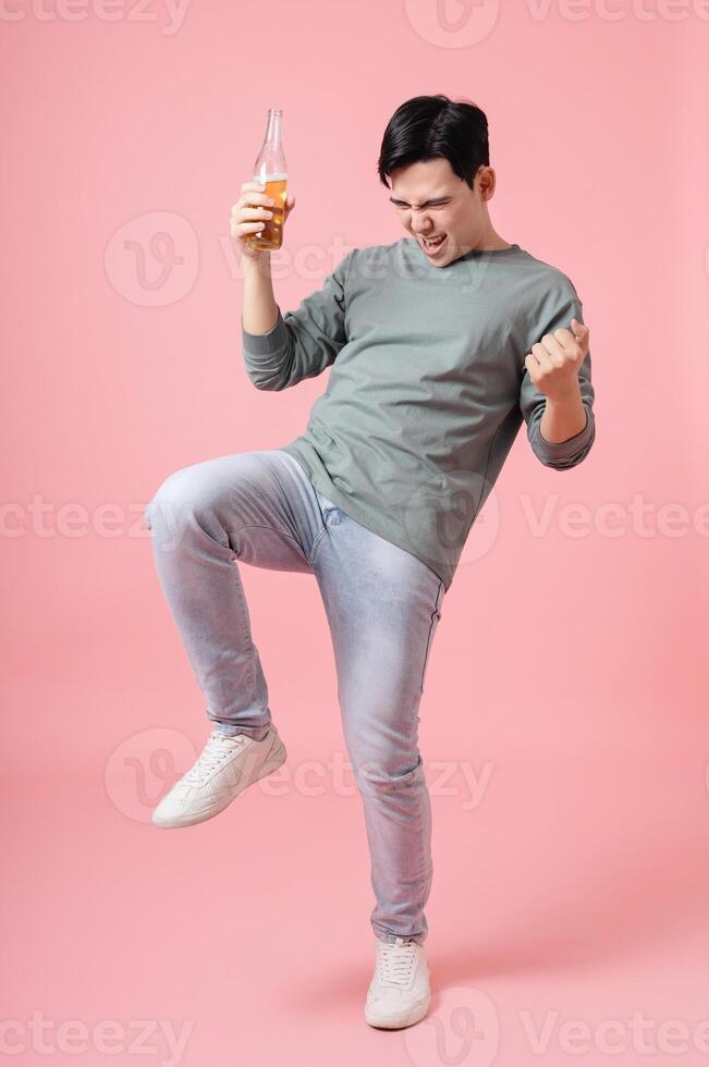 Photo of young Asian man drinking alcohol on background