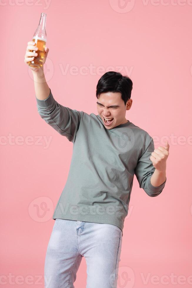 Photo of young Asian man drinking alcohol on background