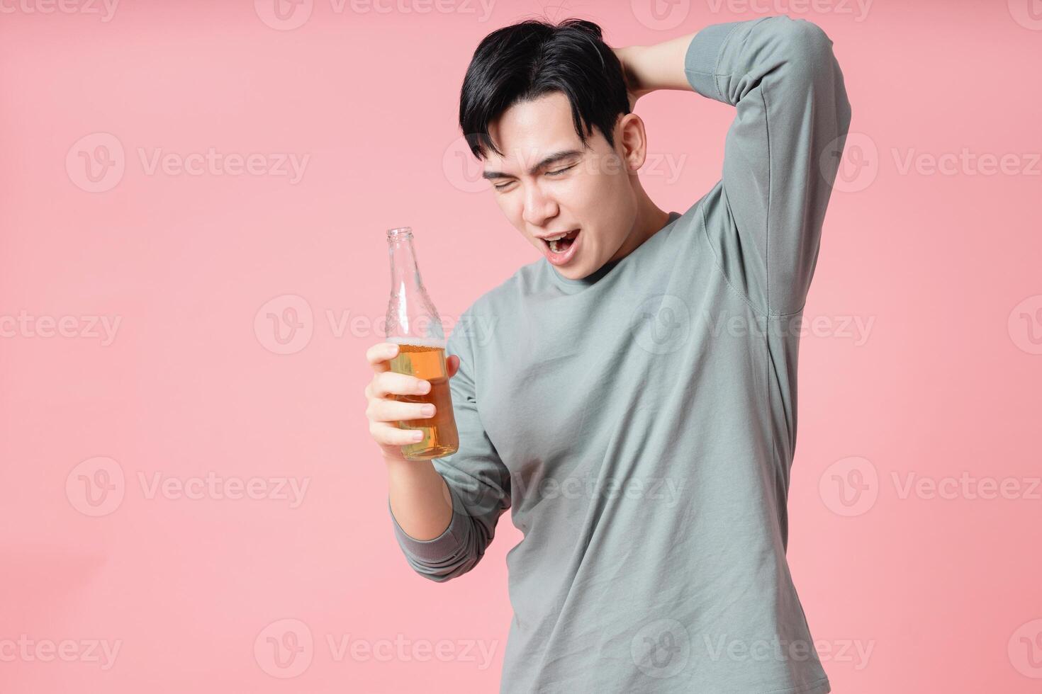 Photo of young Asian man drinking alcohol on background