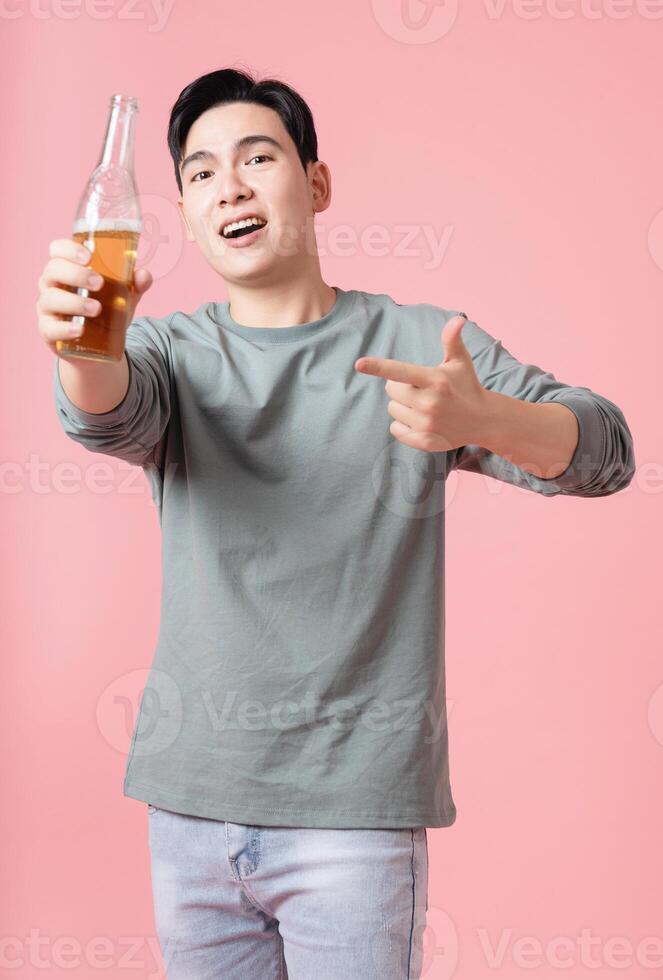 Photo of young Asian man drinking alcohol on background