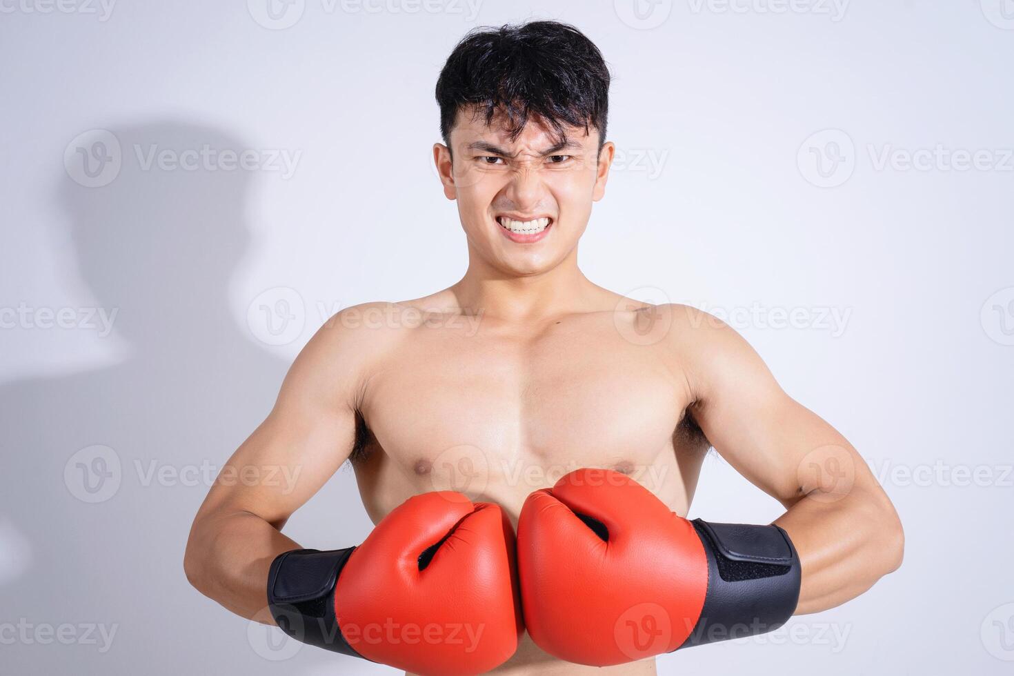 Photo of young Asian boxer on white background