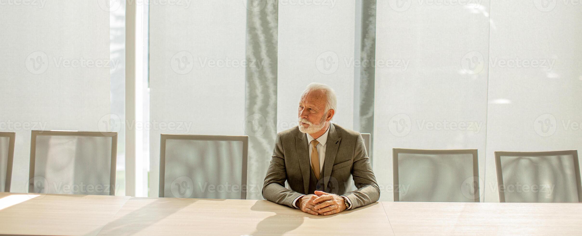 Senior business man sitting in the boardroom at the office photo