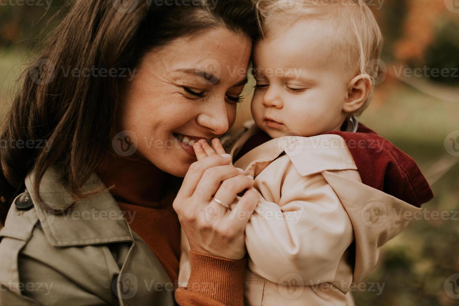 Young woman holding cute baby girl in the autumn park photo