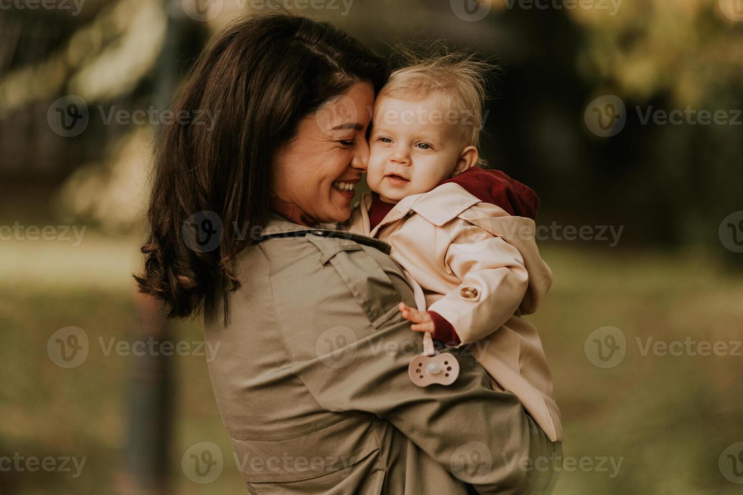 joven mujer participación linda bebé niña en el otoño parque foto