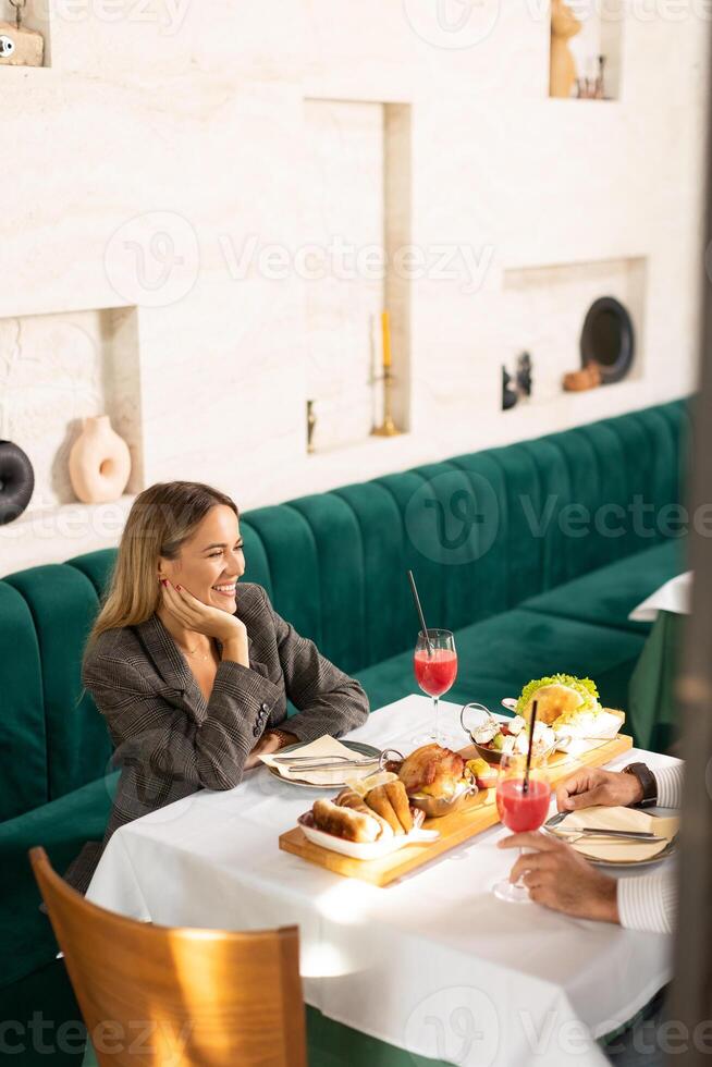 Young couple having lunch and drinking fresh squeezed juice in the restaurant photo