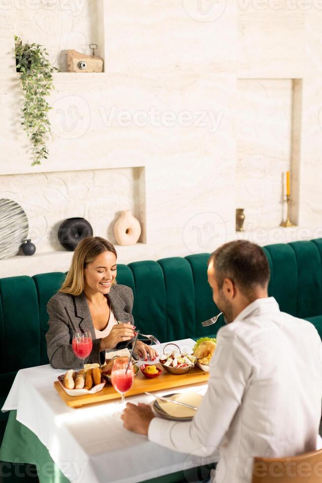 Young couple having lunch and drinking fresh squeezed juice in the restaurant photo