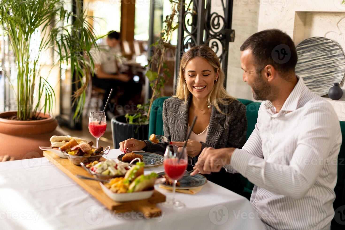 Young couple having lunch and drinking fresh squeezed juice in the restaurant photo