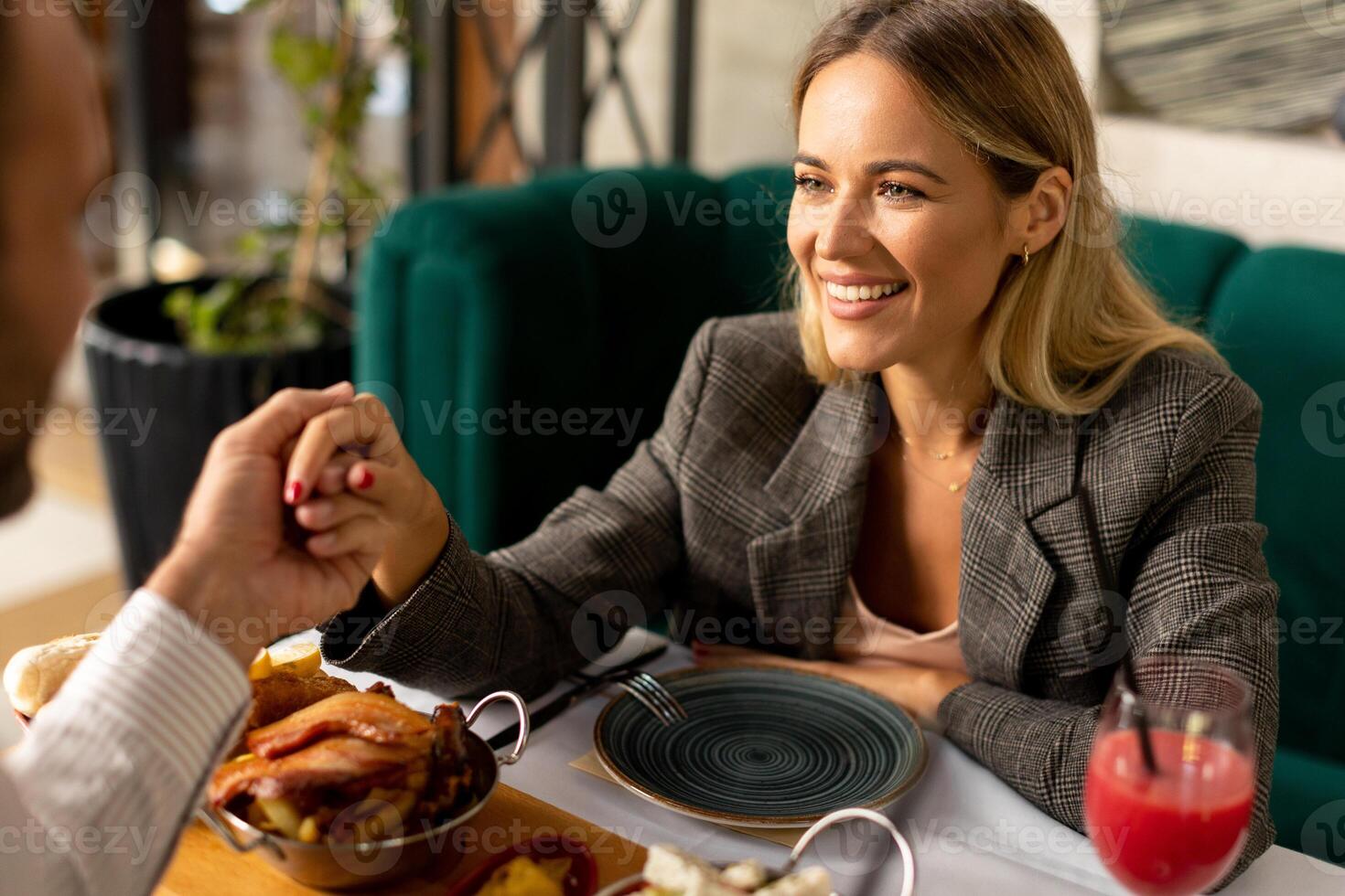 Young couple having lunch and drinking fresh squeezed juice in the restaurant photo